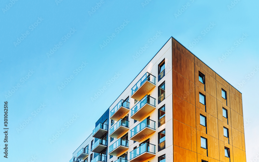 Part of Modern residential apartment with flat building exterior. Detail of New luxury house and home complex. Fragment of City Real estate property and condo architecture. Copy space. Blue sky - obrazy, fototapety, plakaty 