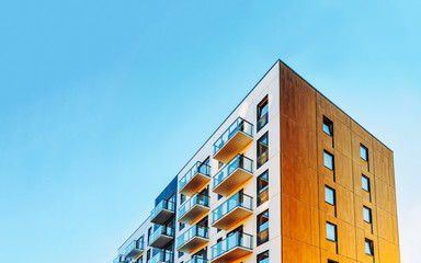 Part of Modern residential apartment with flat building exterior. Detail of New luxury house and home complex. Fragment of City Real estate property and condo architecture. Copy space. Blue sky