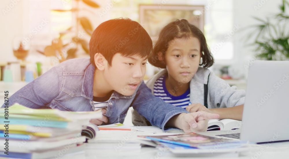 Young asian boy and girl playing with laptop computer at home. Young asian boy and girl playing with laptop computer at home.