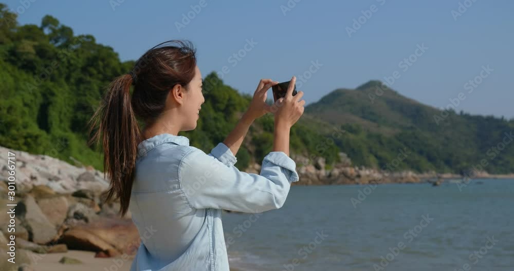 Woman take photo on cellphone at seaside Woman take photo on cellphone at seaside