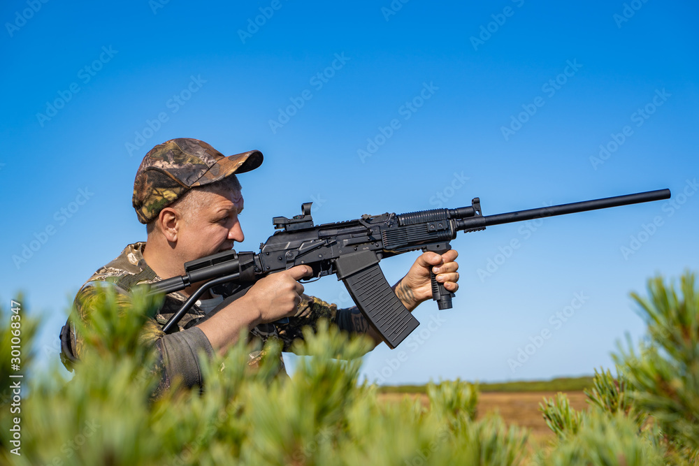 man with a gun standing in the field