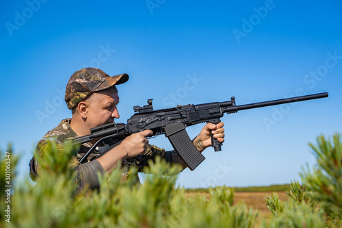 man with a gun standing in the field