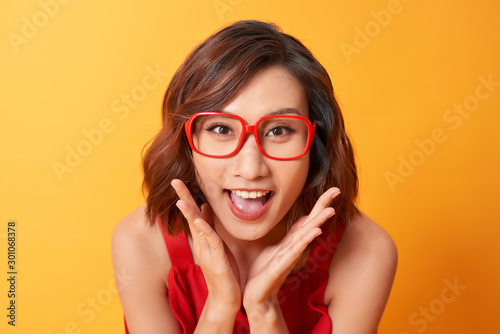 Image of screaming excited young cute woman posing isolated over yellow background.