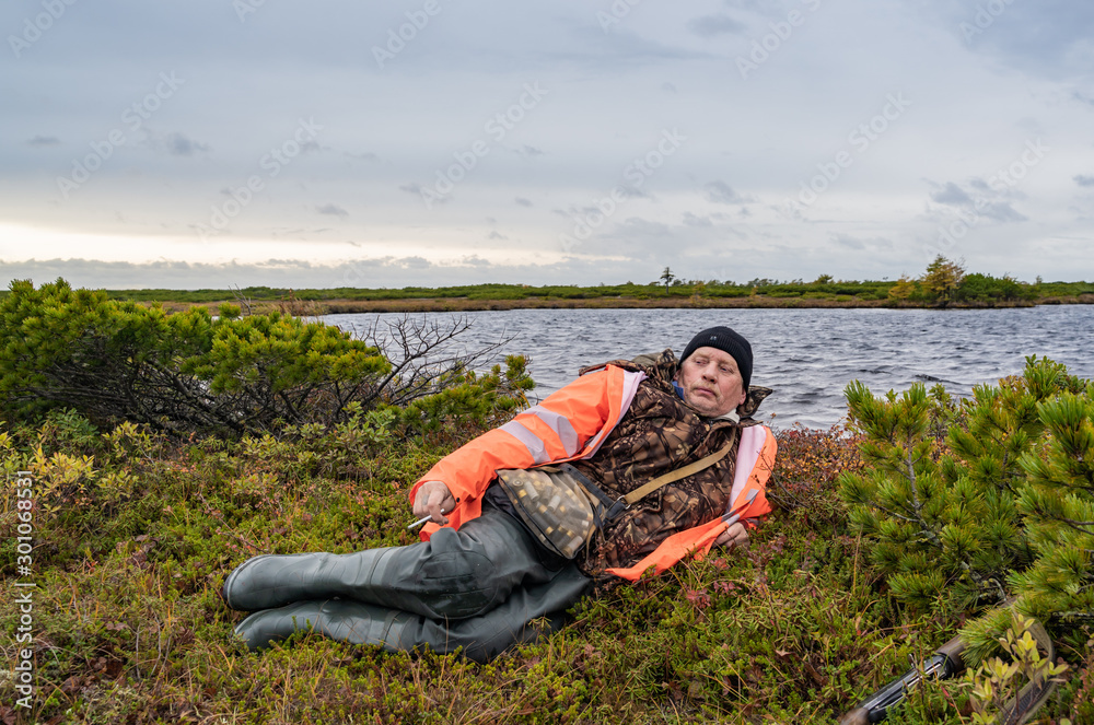 Fototapeta premium man with a gun resting in the field
