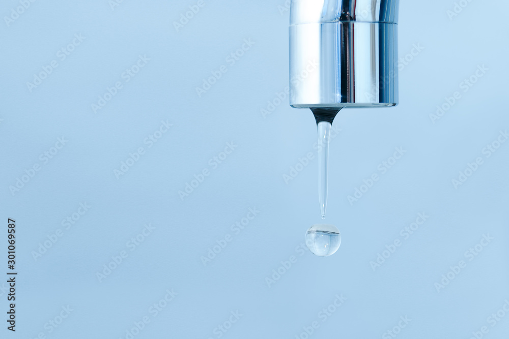 Drops of water flowing from a faucet in the bathroom Drops of water flowing from a faucet in the bathroom