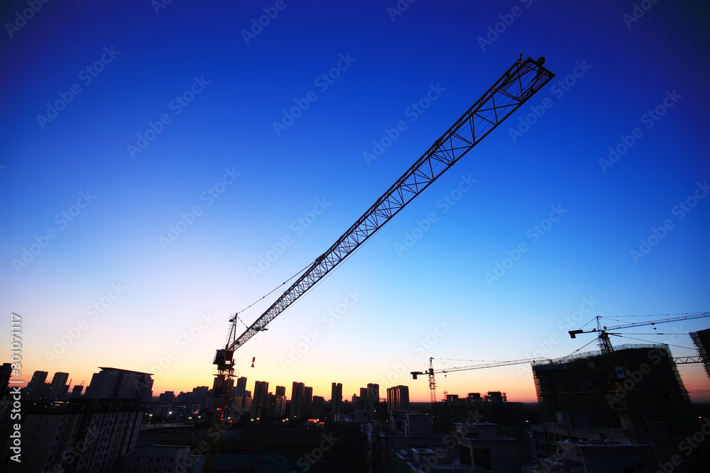 Tower cranes build residential buildings at nigh