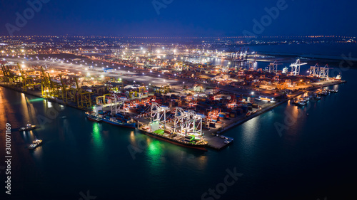 seaport terminal storage containers and shipping cargo containers loading and unloading at night aerial view