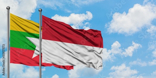 Myanmar and Indonesia flag waving in the wind against white cloudy blue sky together. Diplomacy concept, international relations.