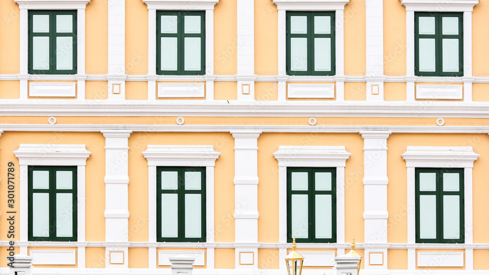 Fototapeta premium Green windows on a yellow building