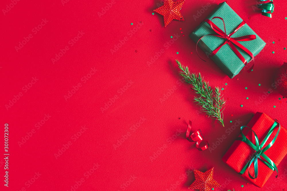 Christmas composition. Gift box, christmas decorations on red background. Flat lay, top view, copy space - obrazy, fototapety, plakaty 