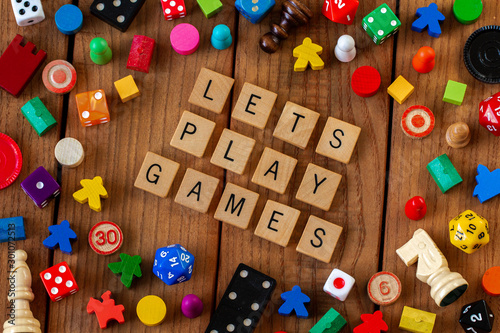 Photos "Lets Play Games" spelled out in wooden letter tiles