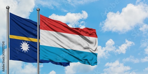 Nauru and Luxembourg flag waving in the wind against white cloudy blue sky together. Diplomacy concept, international relations.