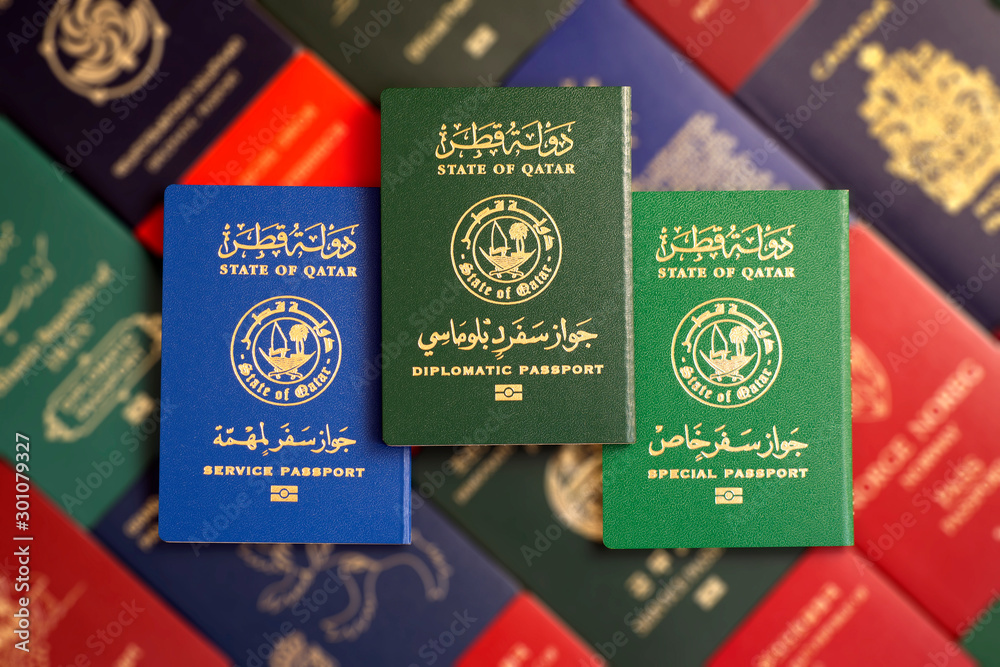 Naklejka premium Various Qatar state passports on a blurred background of passports of the countries of the world.