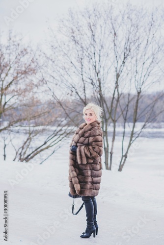 Vogue concept. Beautiful lady in holidays, modern woman wear fur coat look . Fashionable lady outdoors portrait