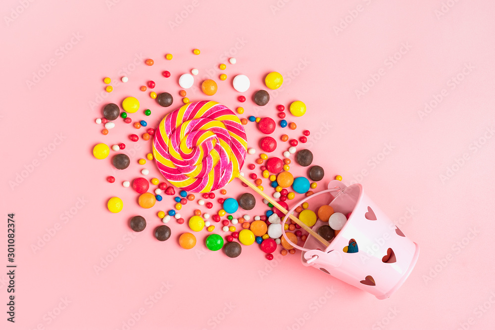 mix colorful chocolate sweets spilled out of bucket with hearts on a pink background Flat lay Top view Place for text Holiday card Happy birthday party, Happy Valentine's day concept