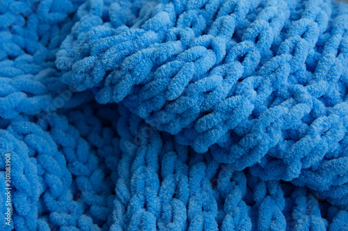 Blue knitted scarf fabric, large knitting, closeup.