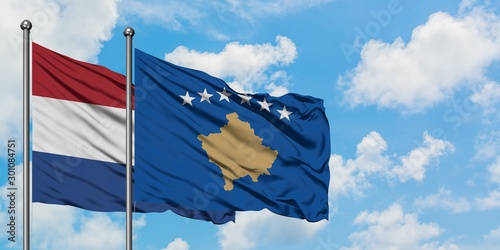 Netherlands and Kosovo flag waving in the wind against white cloudy blue sky together. Diplomacy concept, international relations.