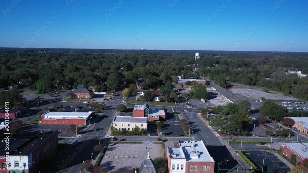 Slow descent on the Old Monroe NC Court house. Starting above the clock tower on the front side of the building with sun shinning on the property. City buildings in the background. Slow descent on the Old Monroe NC Court house. Starting above the clock tower on the front side of the building with sun shinning on the property. City buildings in the background.