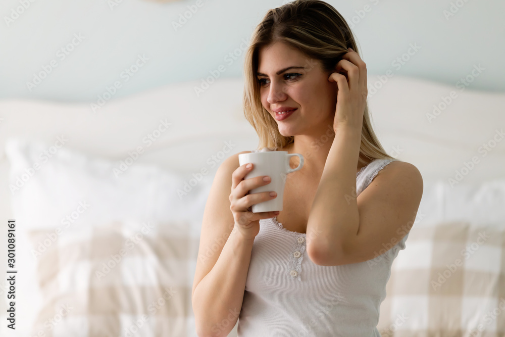 Young beautiful woman sitting on bed at home Young beautiful woman sitting on bed at home