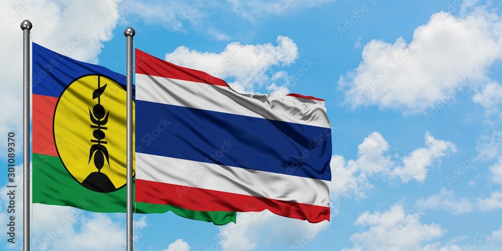 New Caledonia and Thailand flag waving in the wind against white cloudy blue sky together. Diplomacy concept, international relations.