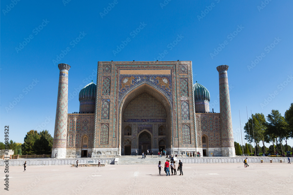 Tourists on Registan Square in front of Sherdor Madrasah in Samarkand, Uzbekistan