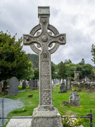 Traditional celtic cross tombstone with engraved ornaments in Irish cementery