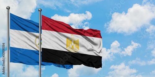 Nicaragua and Egypt flag waving in the wind against white cloudy blue sky together. Diplomacy concept, international relations.