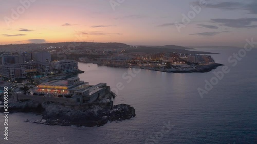 High Aerial shot orbiting around the coast of St Julians Malta. Baech at the sunset