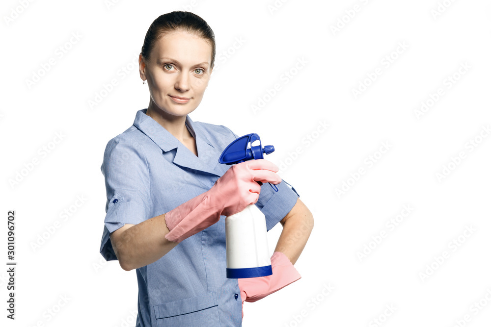 Attractive woman maid in special clothes holds in her hands chemical spray bottle on a white background. Attractive woman maid in special clothes holds in her hands chemical spray bottle on a white background.