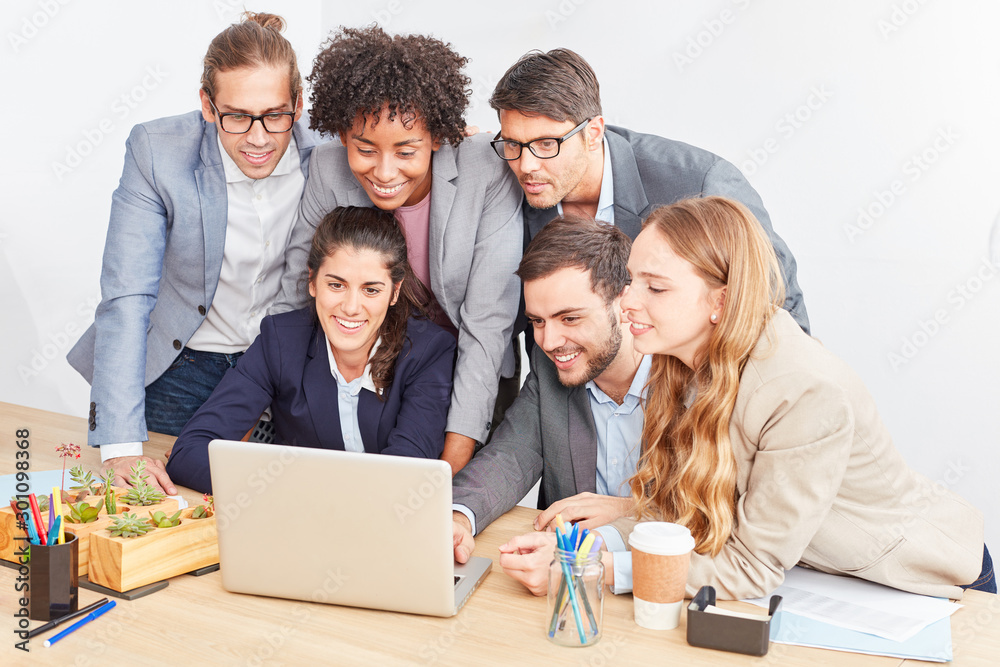 Internet start-up team looks together on laptop