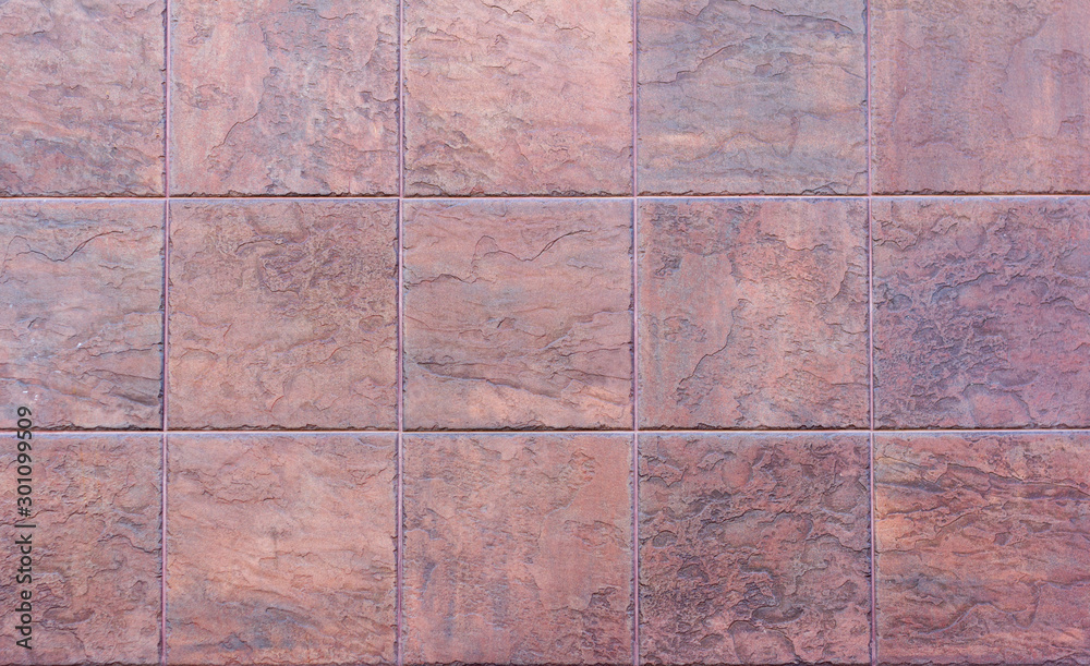 Fototapeta premium Decorative tiles of brown stone, background.The texture of the stone tiles.