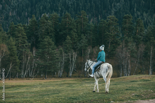 Teen girl riding a horse on meadow