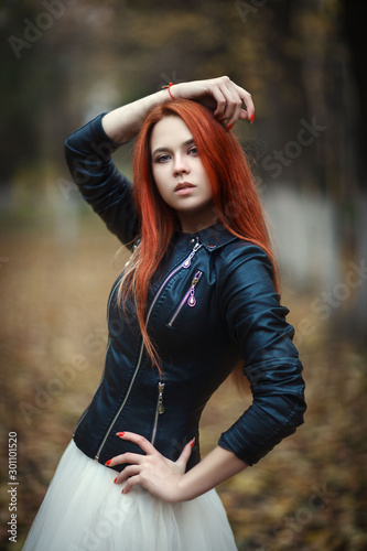 Beautiful girl is posing in an autumn park
