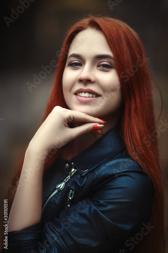 Beautiful girl is posing in an autumn park