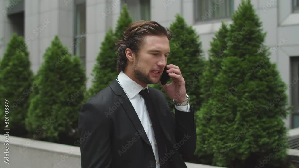 Handsome businessman talks on the phone. The man is extremely angry. Handsome businessman talks on the phone. The man is extremely angry.