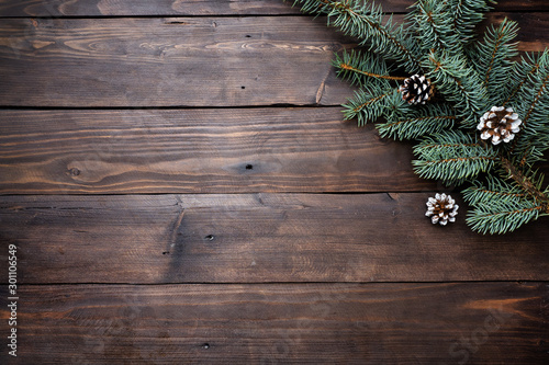 Christmas tree with cones on a dark wooden background. Copy space. Flat lay.