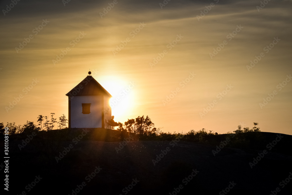 Peaceful man enjoying the sunset near with lighthouse Norway