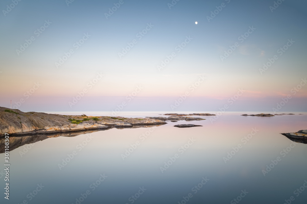 Moon shining at prisma color twilight over seascape with isle Norway coastal