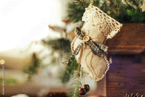 Rustic natural background. Handmade Christmas decorations hang on a Christmas tree. The concept of the new year, christmas and winter holidays. photo