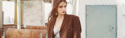 attractive elegant model posing in silk dress and brown jacket on roof