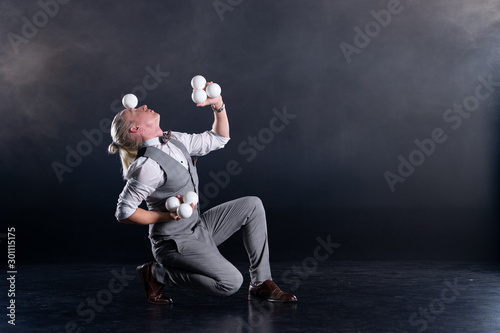 Juggler wearing a suit like a businessman with white balls. concept of success and management