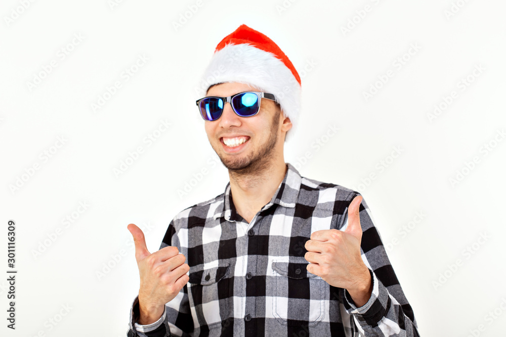 Portrait of a funny young man in Santa Claus hat and beard on white background. Christmas.