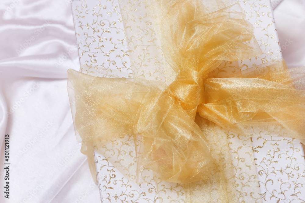White box with golden bow isolated on white background. Luxury product package. White box with golden bow isolated on white background. Luxury product package.