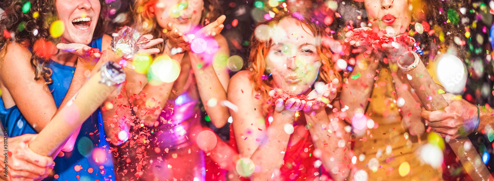 Young friends having party throwing confetti - Young people celebrating on weekend night - Entertainment, fun, new year's eve, nightlife, holidays, concept - Focus on red hair girl hands - obrazy, fototapety, plakaty 