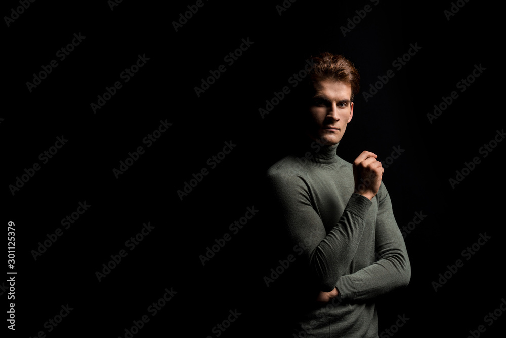 handsome pensive man posing isolated on black