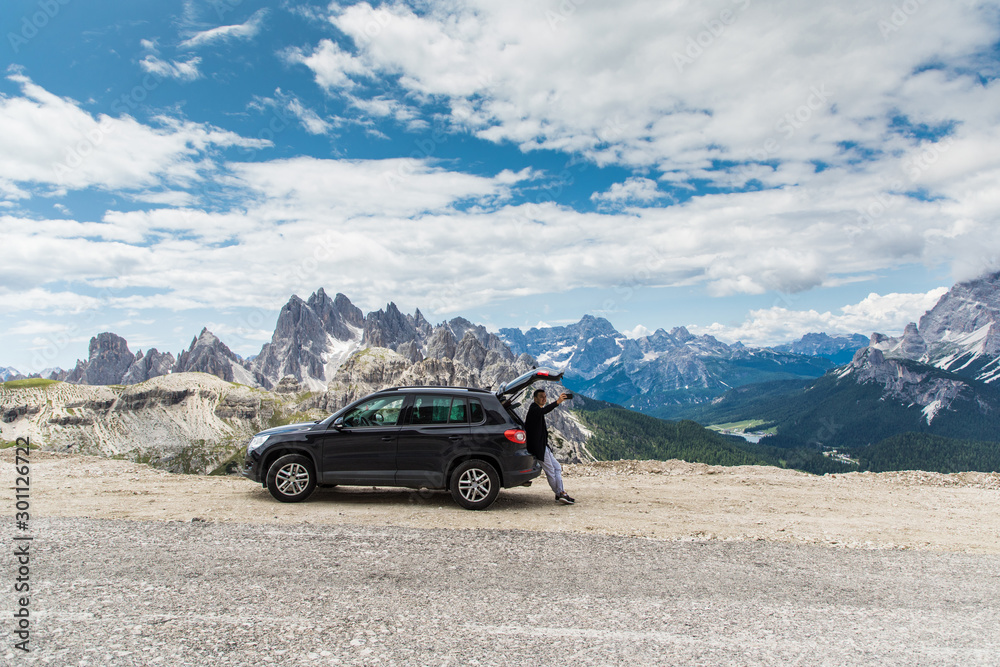 Young handsome man sitting in car trunk take selfie of beauty landscape of mountains Young handsome man sitting in car trunk take selfie of beauty landscape of mountains
