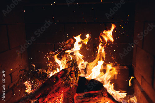 burning fire logs with sparks in the fireplace photo