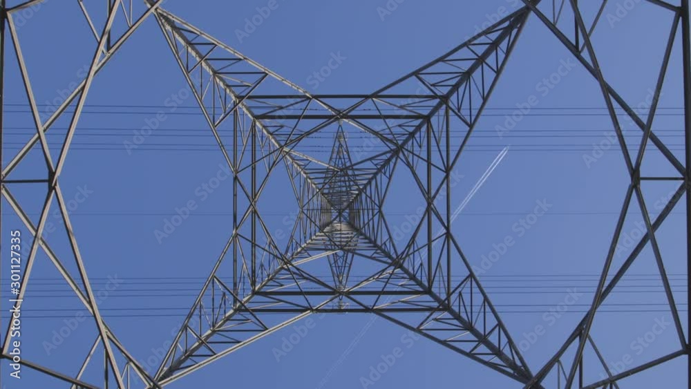 high voltage pylon against blue sky