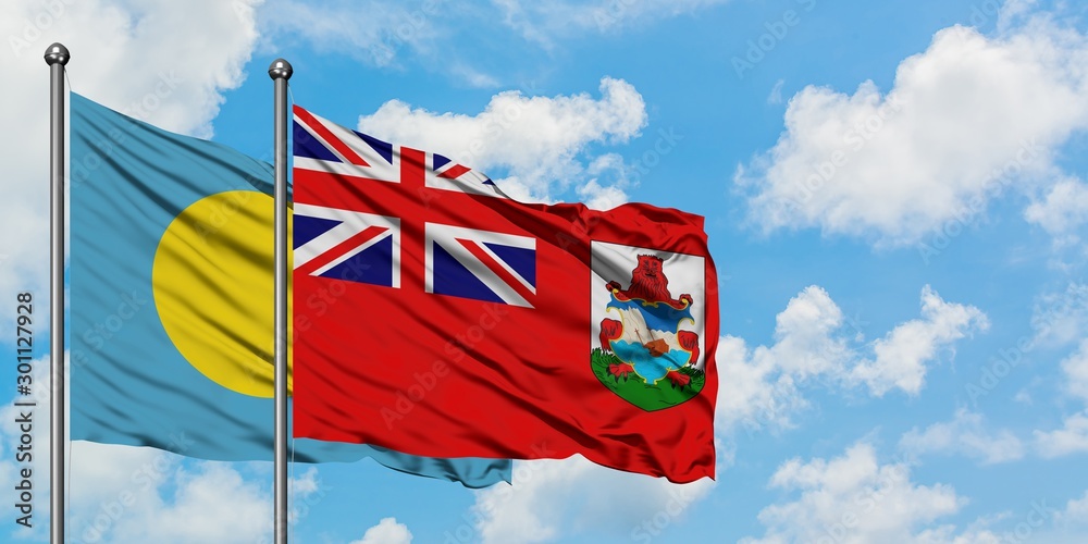 Palau and Bermuda flag waving in the wind against white cloudy blue sky together. Diplomacy concept, international relations.