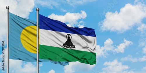 Palau and Lesotho flag waving in the wind against white cloudy blue sky together. Diplomacy concept, international relations.
